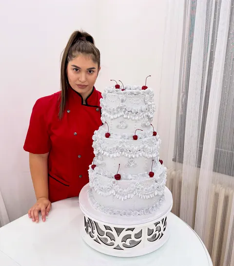 Marija pored velike bele torte na više spratova
