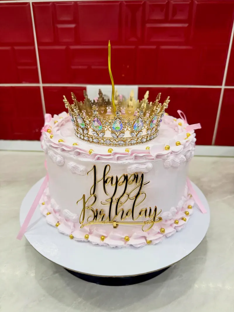 Bela rođendanska torta sa krunom i natpisom Happy Birthday